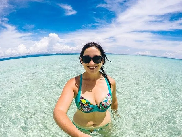 Woman in bikini smiling in clear shallow water at Kalanggaman Island