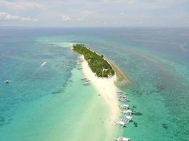 Aerial view of Kalanggaman Island with long white sandbar and boats