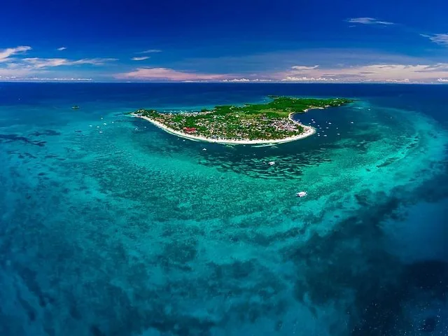 Aerial view of a tropical island surrounded by clear blue water