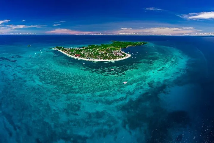 Luftaufnahme der Insel Malapascua, umgeben von türkisfarbenem Wasser und Korallenriffen.